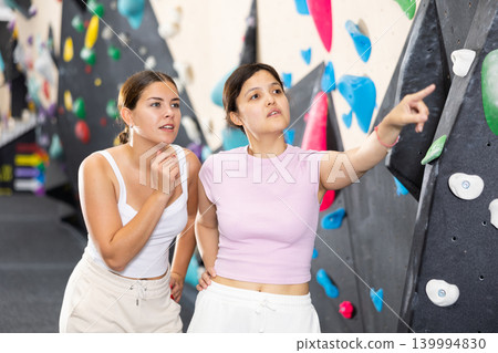 Two young women posing against climbing wall Two young women posing against climbing wall 139994830