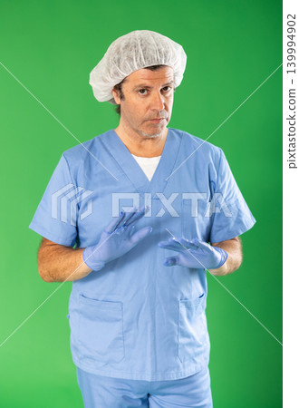 Man in blue surgery suit on green screen background speaks to imaginary partner. Man in blue surgery suit on green screen background speaks to imaginary partner. 139994902
