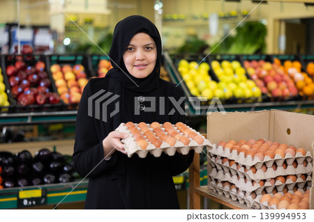Young woman in hijab buys eggs in grocery store Young woman in hijab buys eggs in grocery store 139994953