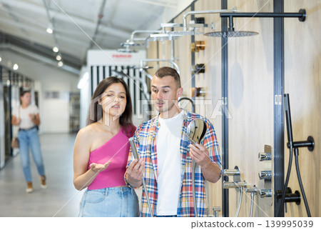 Couple man and woman choosing shower head Couple man and woman choosing shower head 139995039