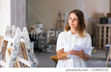 Female architect matching check list during repair works Female architect matching check list during repair works 139995135