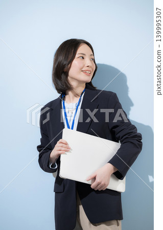 回顧這位可愛、敬業的女員工的形象：她戴著名牌，手持筆記型電腦，背景是淺藍色，代表著商業和IT產業。 139995307