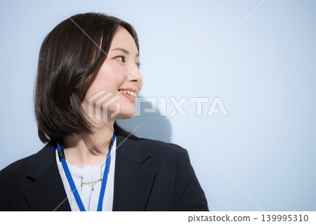 A close-up of a cute female employee's upper body as she turns around, looks up, and smiles, representing the image of a business and IT professional. A close-up of a cute female employee's upper body as she turns around, looks up, and smiles, representing the image of a business and IT professional. 139995310