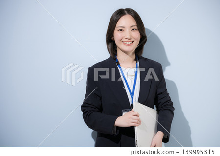 一位可愛的職業女員工,手持筆記型電腦,代表商務和IT產業,面帶微笑地看著鏡頭。 一位可愛的職業女員工,手持筆記型電腦,代表商務和IT產業,面帶微笑地看著鏡頭。 139995315