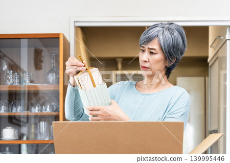 一位老婦人在整理她的物品 139995446