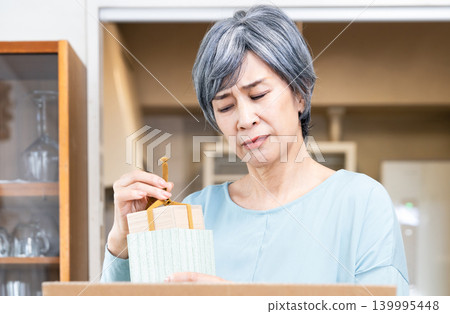 一位老婦人在整理她的物品 139995448