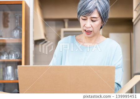 Senior woman decluttering her belongings 139995451