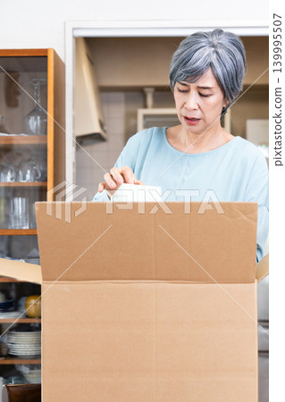 Senior woman decluttering her belongings 139995507