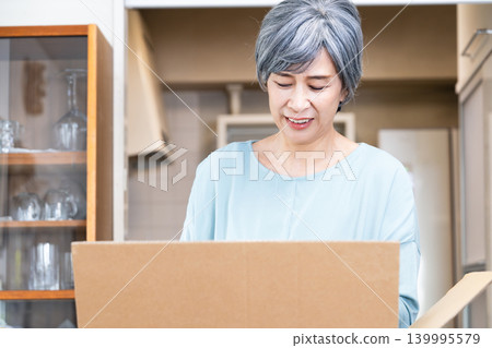 一位老婦人在整理她的物品 139995579