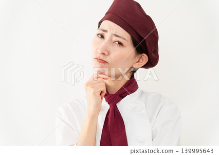 A woman wearing a baker's uniform A woman wearing a baker's uniform 139995643