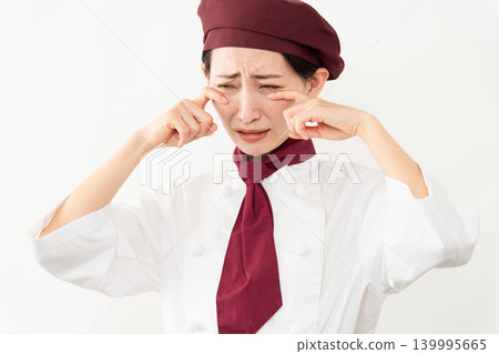 A woman wearing a baker's uniform 139995665