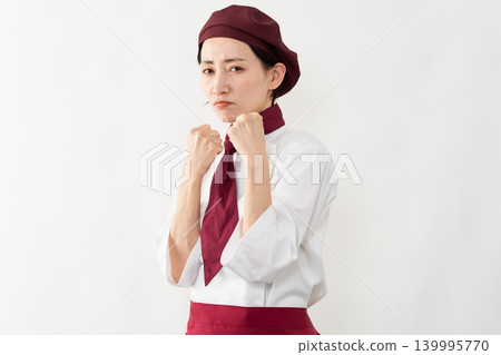 A woman wearing a baker's uniform A woman wearing a baker's uniform 139995770