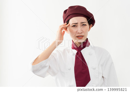 A woman wearing a baker's uniform A woman wearing a baker's uniform 139995821