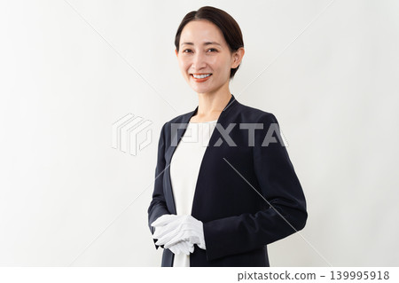 A woman in a business suit and white gloves - Brand image A woman in a business suit and white gloves - Brand image 139995918
