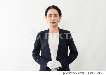 A woman in a business suit and white gloves - Brand image A woman in a business suit and white gloves - Brand image 139995936