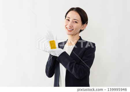 一位身著職業套裝的女士手持金錠－品牌形象 139995946