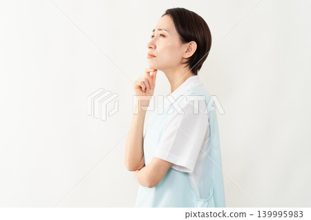 A woman wearing a light blue apron; a caregiver image. A woman wearing a light blue apron; a caregiver image. 139995983