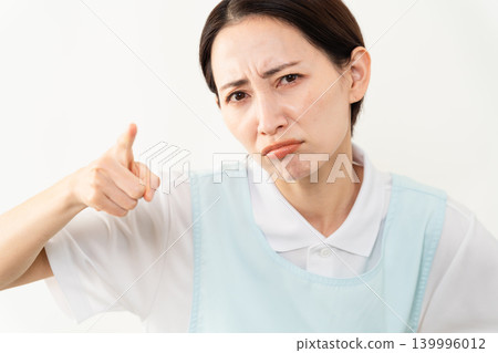 A woman wearing a light blue apron; a caregiver image. A woman wearing a light blue apron; a caregiver image. 139996012