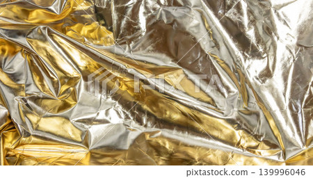 A background image where silver and gold metallic sheen intersect, emitting an irregular shimmer. 139996046