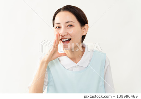 一位身穿淺藍色圍裙的女士;護理人員的形象。 一位身穿淺藍色圍裙的女士;護理人員的形象。 139996469