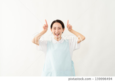 一位身穿淺藍色圍裙的女士；護理人員的形象。 139996494