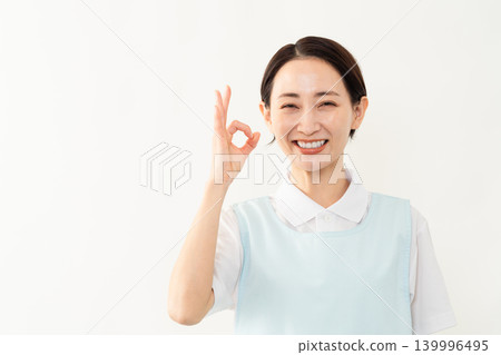 一位身穿淺藍色圍裙的女士；護理人員的形象。 139996495