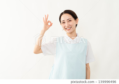 一位身穿淺藍色圍裙的女士;護理人員的形象。 一位身穿淺藍色圍裙的女士;護理人員的形象。 139996496