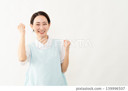 一位身穿淺藍色圍裙的女士;護理人員的形象。 一位身穿淺藍色圍裙的女士;護理人員的形象。 139996507