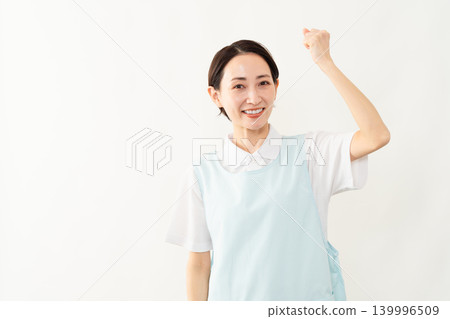 一位身穿淺藍色圍裙的女士;護理人員的形象。 一位身穿淺藍色圍裙的女士;護理人員的形象。 139996509