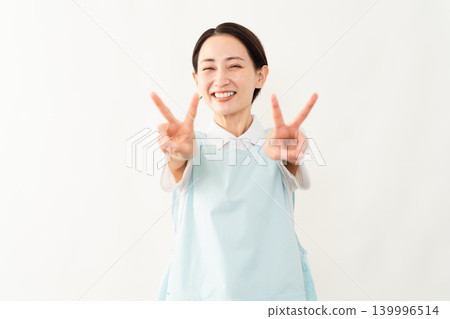 一位身穿淺藍色圍裙的女士；護理人員的形象。 139996514