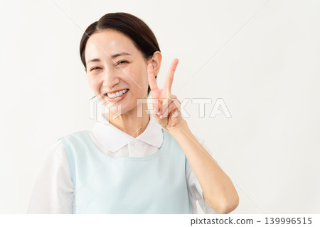 一位身穿淺藍色圍裙的女士;護理人員的形象。 一位身穿淺藍色圍裙的女士;護理人員的形象。 139996515