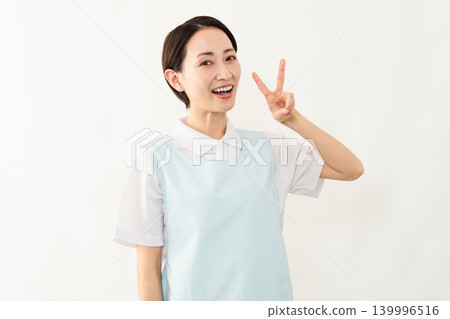 一位身穿淺藍色圍裙的女士;護理人員的形象。 一位身穿淺藍色圍裙的女士;護理人員的形象。 139996516