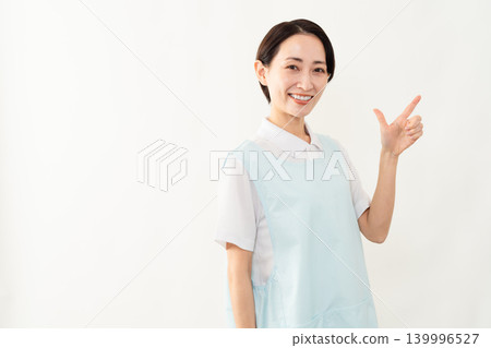 一位身穿淺藍色圍裙的女士；護理人員的形象。 139996527