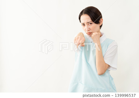 一位身穿淺藍色圍裙的女士;護理人員的形象。 一位身穿淺藍色圍裙的女士;護理人員的形象。 139996537