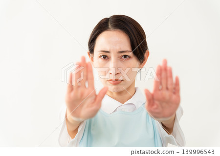 A woman wearing a light blue apron; a caregiver image. A woman wearing a light blue apron; a caregiver image. 139996543