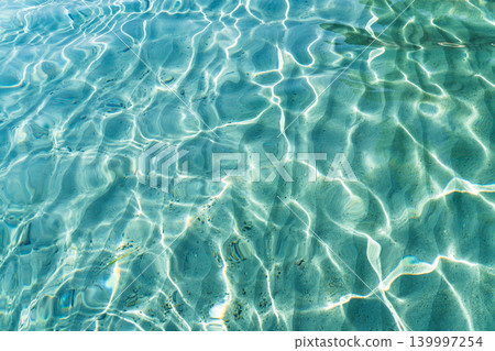 Sunlit crystal clear turquoise water and sand patterns in Sardinia, Italy, reflecting bright, d Sunlit crystal clear turquoise water and sand patterns in Sardinia, Italy, reflecting bright, d 139997254