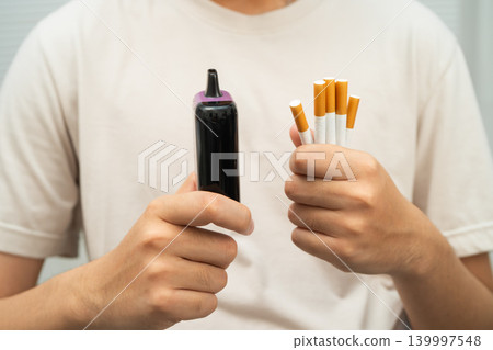 Man holding electronic cigarettes, no smoking. Man holding electronic cigarettes, no smoking. 139997548