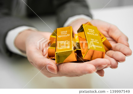 Asian woman holding gold bar in finance business. Asian woman holding gold bar in finance business. 139997549