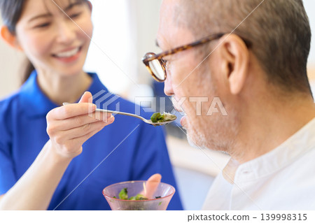 Asian caregivers assisting seniors with meals Asian caregivers assisting seniors with meals 139998315