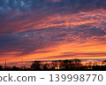 Spectacular sunset sky with vibrant orange and purple clouds over trees 139998770