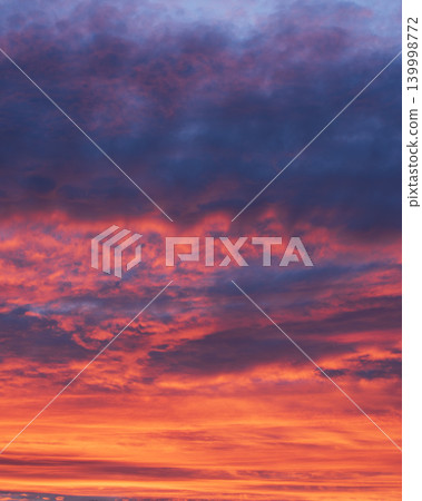 Vertical dramatic sunset sky with vibrant orange and dark purple clouds Vertical dramatic sunset sky with vibrant orange and dark purple clouds 139998772