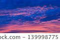 Dramatic colorful sunset clouds glowing across deep blue evening sky 139998775