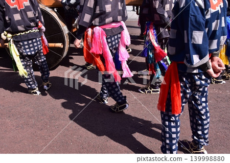Men participating in the Inuyama Festival in Aichi Prefecture, dressed in traditional happi coats, straw sandals, and brightly colored sashes, are pictured alongside the large wheels of the floats. Men participating in the Inuyama Festival in Aichi Prefecture, dressed in traditional happi coats, straw sandals, and brightly colored sashes, are pictured alongside the large wheels of the floats. 139998880