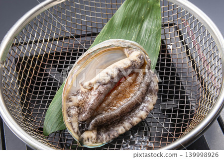 Fresh seafood, live abalone drained in a colander, the moment of Japanese cuisine preparation. 139998926