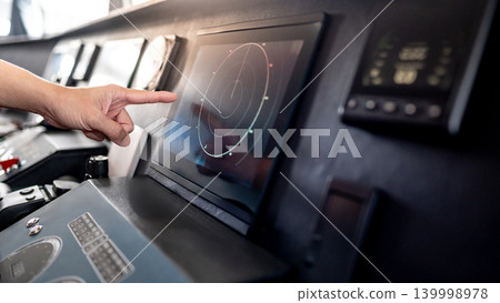 Captain hand pointing at marine radar monitor on boat dashboard Captain hand pointing at marine radar monitor on boat dashboard 139998978