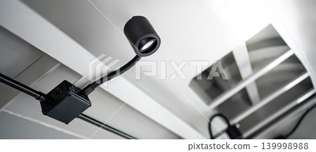 Modern black cylinder LED spotlight or cylindrical downlight hanging on the ceiling Modern black cylinder LED spotlight or cylindrical downlight hanging on the ceiling 139998988