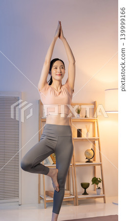 一位女士晚上在家做瑜伽 139999166