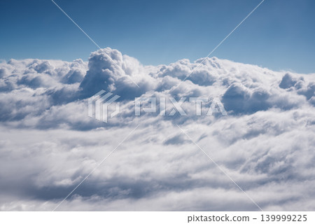 Blue sky and beautiful clouds. Aerial view of white fluffy clouds. View from an airplane on the way to vacation and holidays. Wallpaper background. Copy space Blue sky and beautiful clouds. Aerial view of white fluffy clouds. View from an airplane on the way to vacation and holidays. Wallpaper background. Copy space 139999225