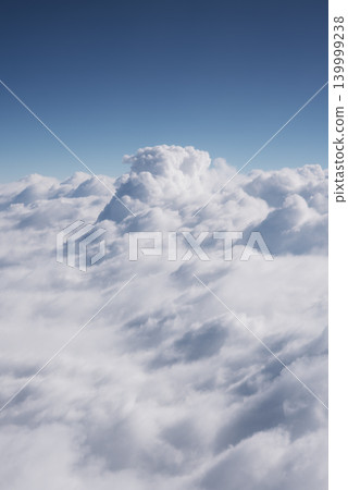 Blue sky and beautiful clouds. Aerial view of white fluffy clouds. View from an airplane on the way to vacation and holidays. Vertical wallpaper background. Copy space Blue sky and beautiful clouds. Aerial view of white fluffy clouds. View from an airplane on the way to vacation and holidays. Vertical wallpaper background. Copy space 139999238