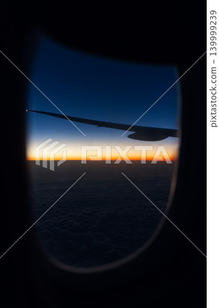 Aerial view from an airplane window of the sunrise, sky, wing. Night flight. Beautiful sunset, view from the airplane window of the sky during the flight. Vacation travel concept. Vertical Copy space Aerial view from an airplane window of the sunrise, sky, wing. Night flight. Beautiful sunset, view from the airplane window of the sky during the flight. Vacation travel concept. Vertical Copy space 139999239